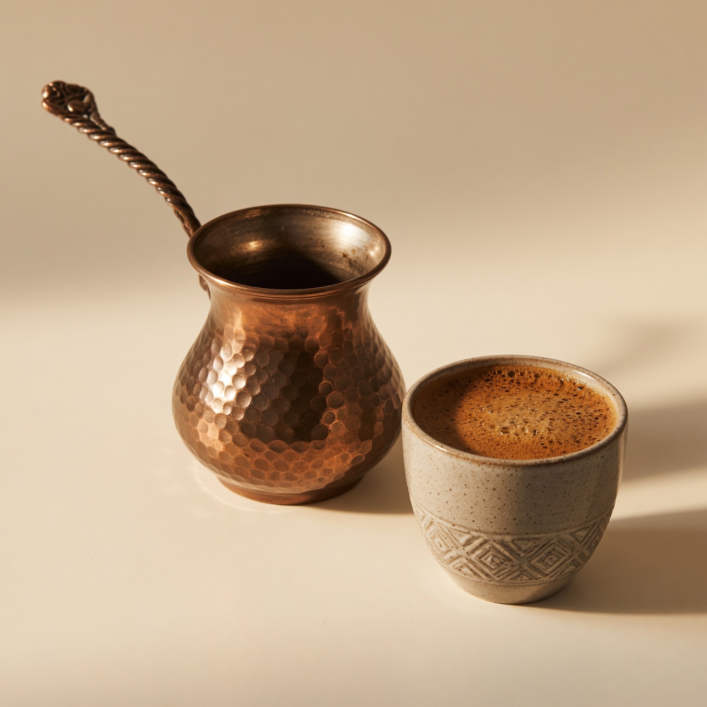 A copper jazve beside a cup of Armenian coffee